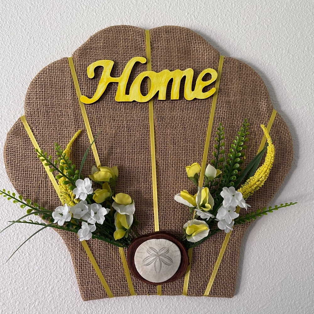 Handmade clam shell wreath made with burlap, ribbon and flowers and sign.